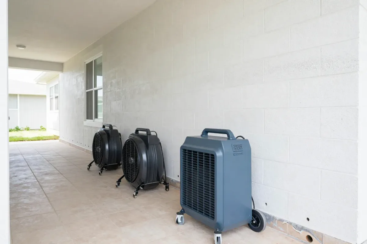 Air movers and a dehumidifier drying a flood-cut hallway in a Lehigh Acres house